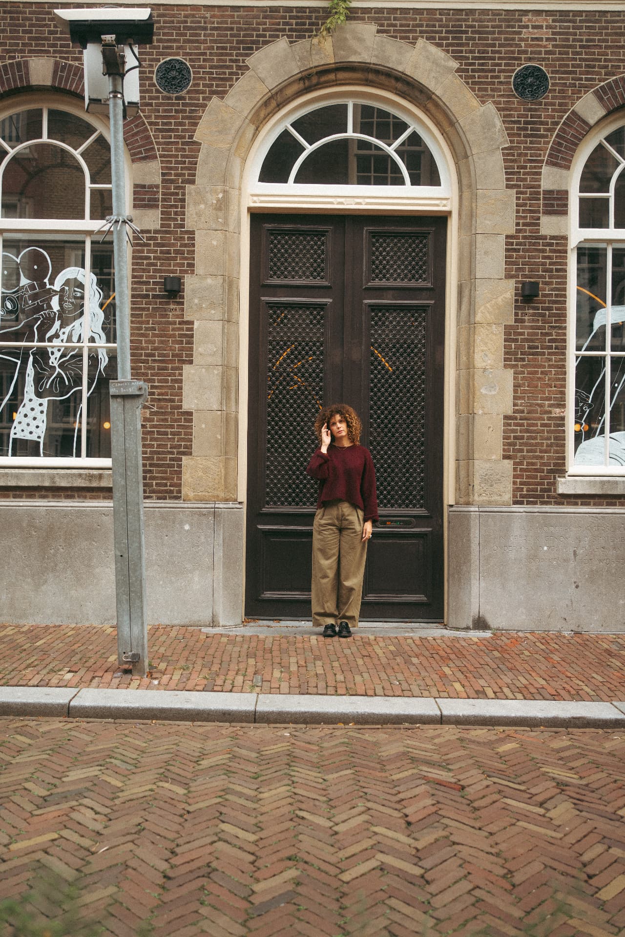 Sabine bij een grote donkere deur in een oude straat
